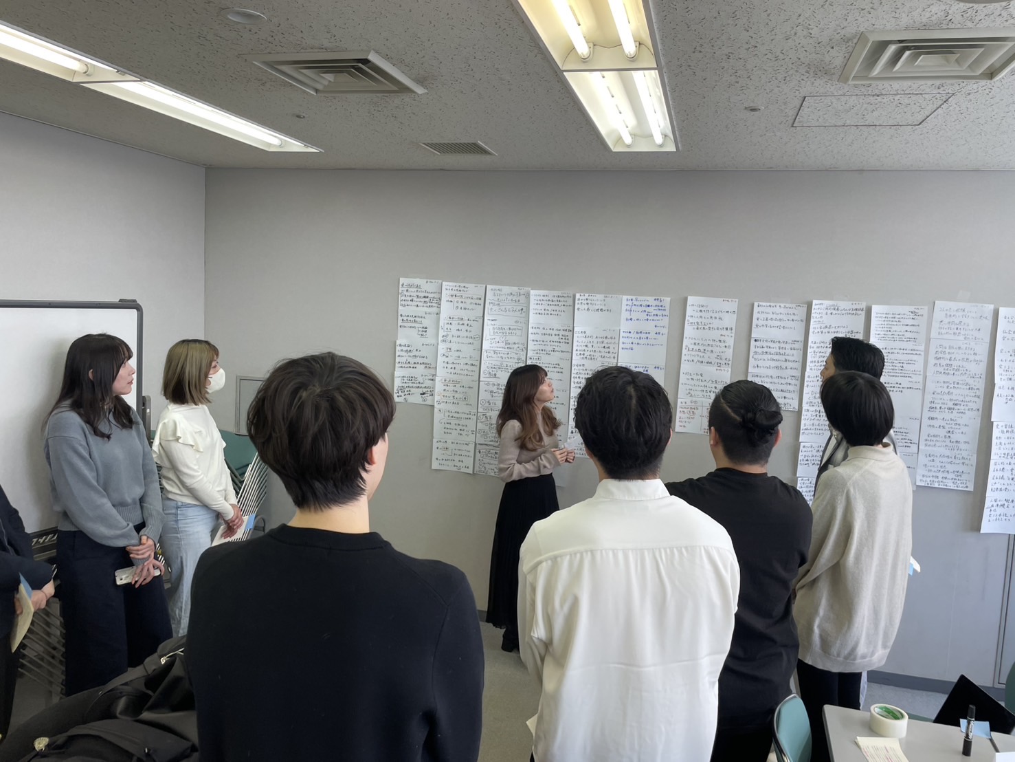 壁に貼られた要約を参加者が見ている写真